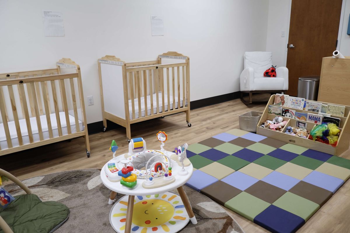 Infant room with cribs and a book display at Newark Nature School, Newark, DE