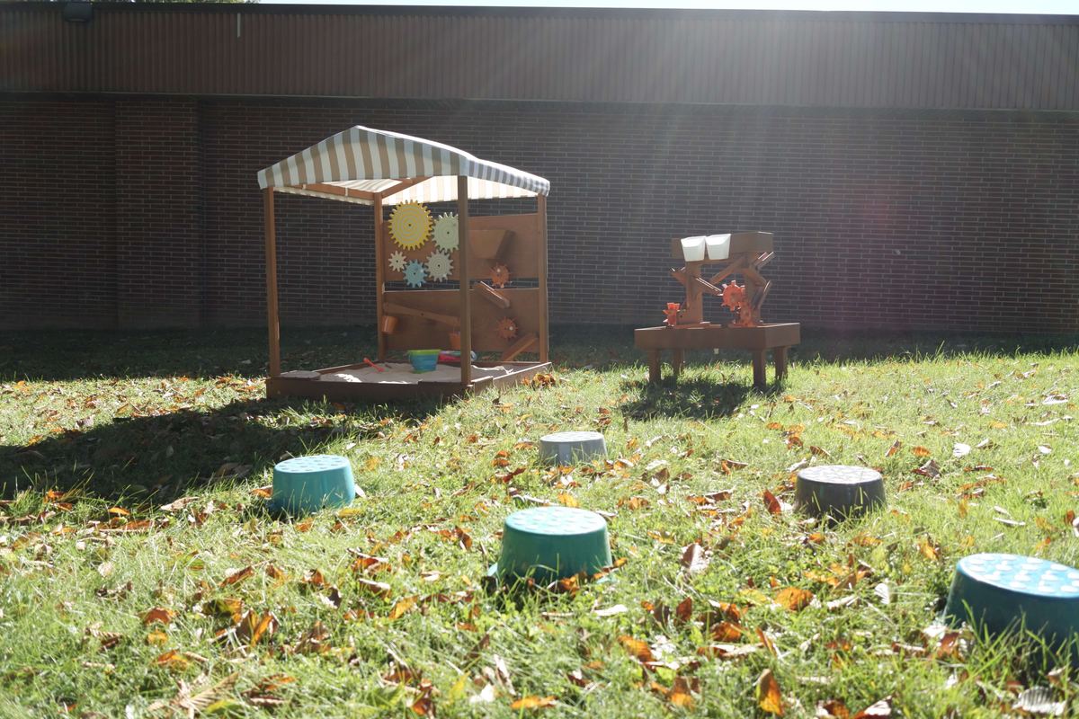 Sand table, water table, and stepping stones on the grass at Newark Nature School, Newark, DE