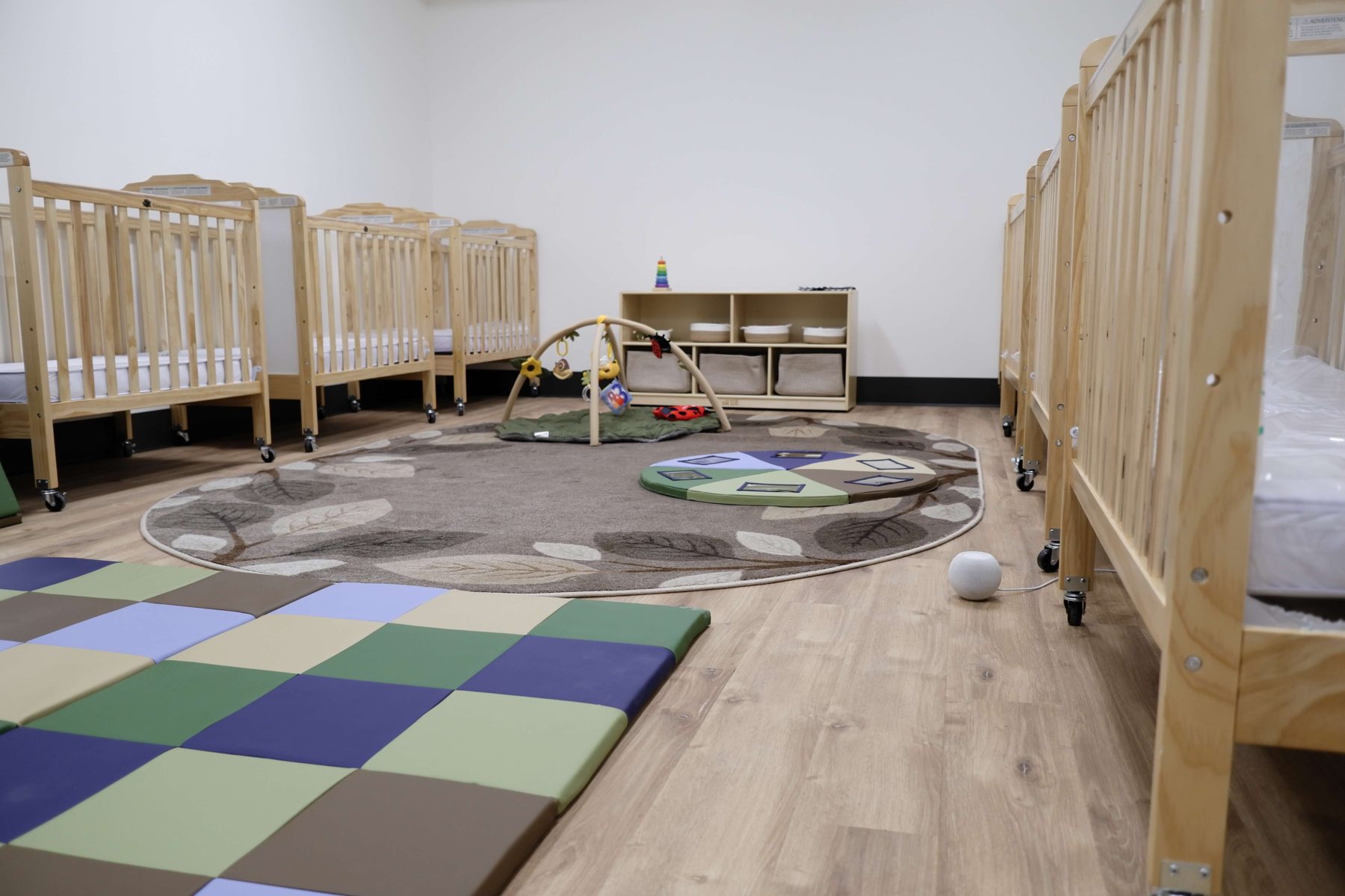 Infant room cribs and play area at Newark Nature School daycare in Newark, DE